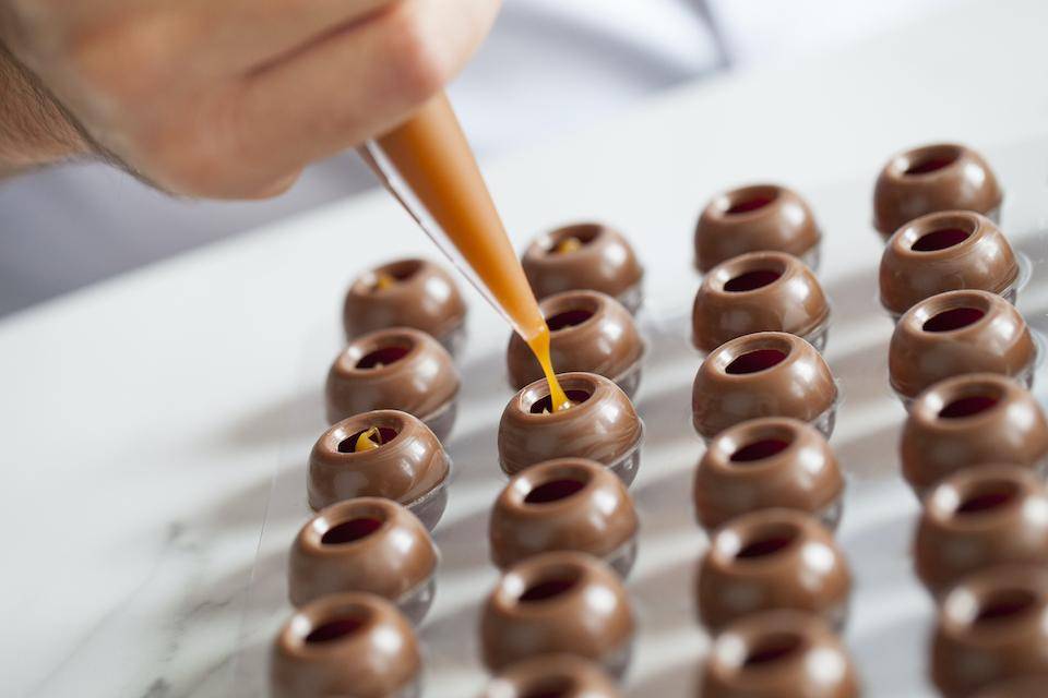 A chef fills truffle shells