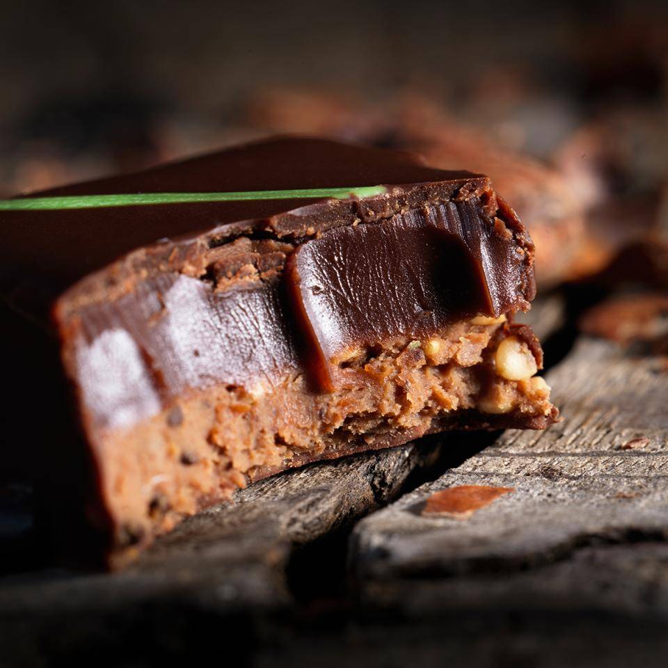 Interior of a dark chocolate bonbon showing layers and ganache texture