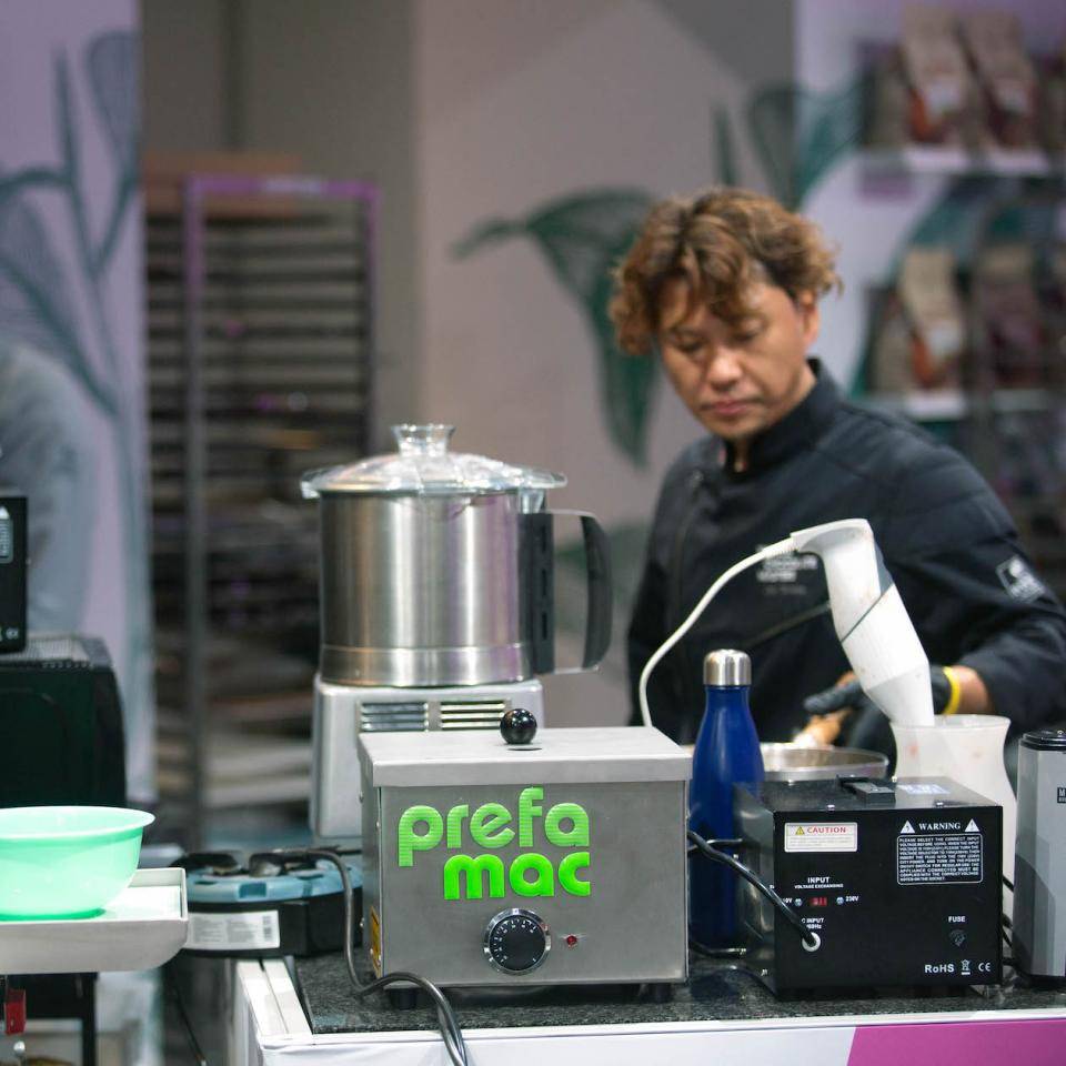 A WCM finalist prepares his entry in the background with a Prefamac machine in the foreground