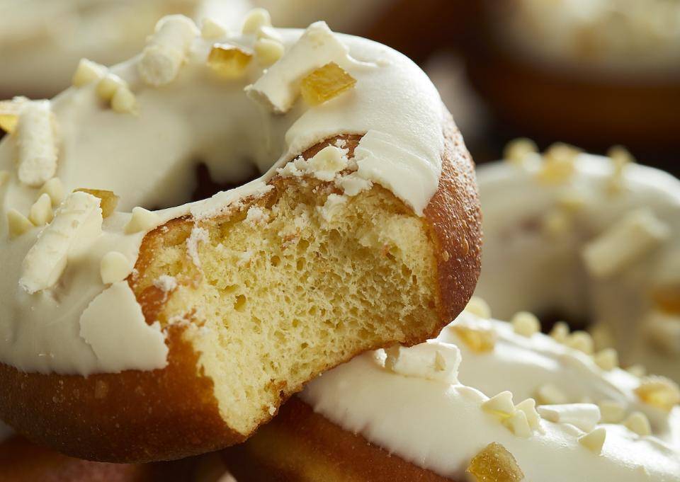 A vegan cake doughnut with white chocolate frosting and small white chocolate curls