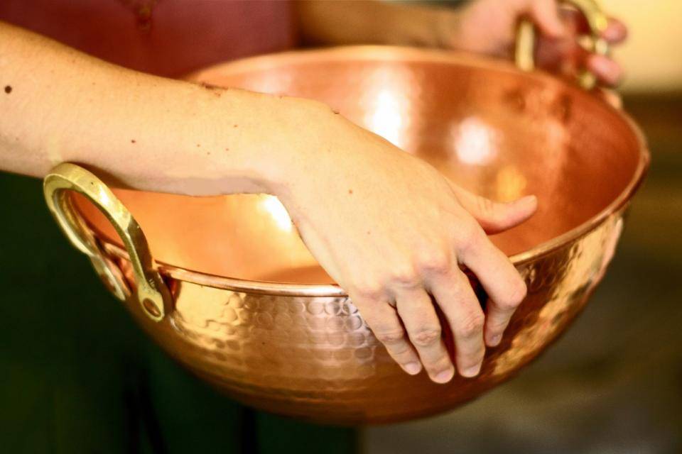 a chef holding a copper bowl