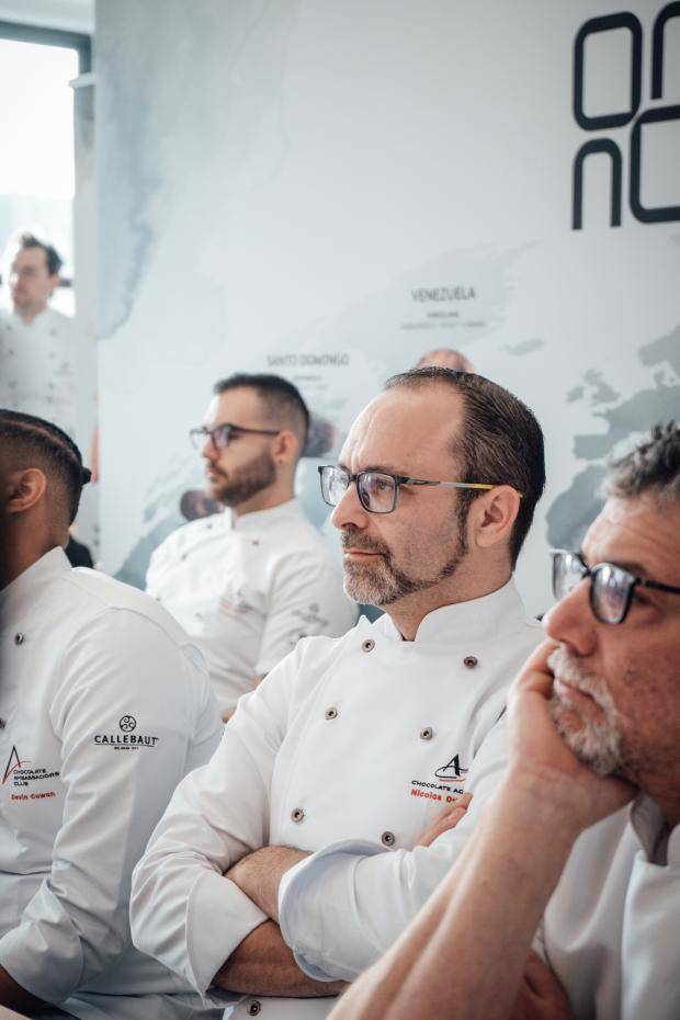 The chefs focus on a presentation, Chef Nicolas Dutertre in the center