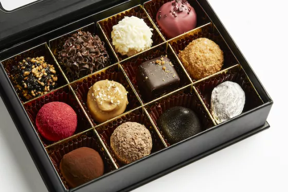 Çeşitli çikolata lezzetlerini sergileyen açık bir kutu