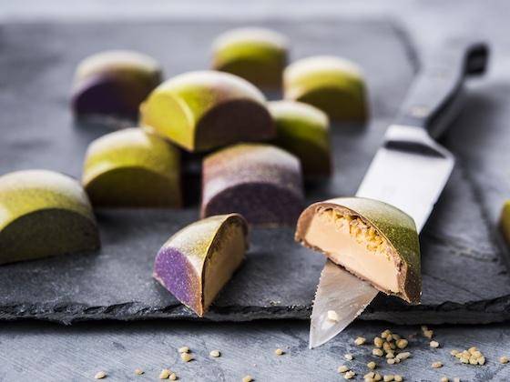 Pistachio pralines with one cut in half to reveal the interior